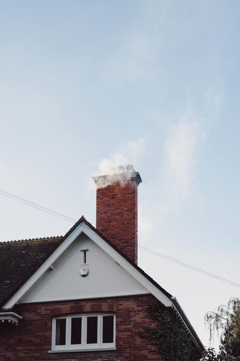 a home’s exterior with a brick chimney.